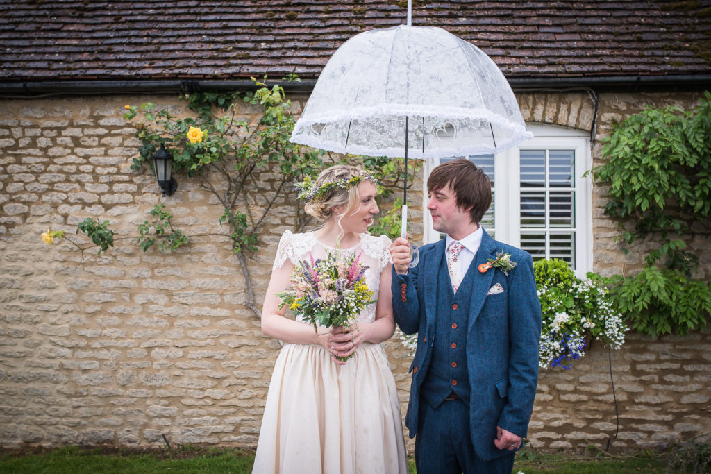 bride and groom under umbrella